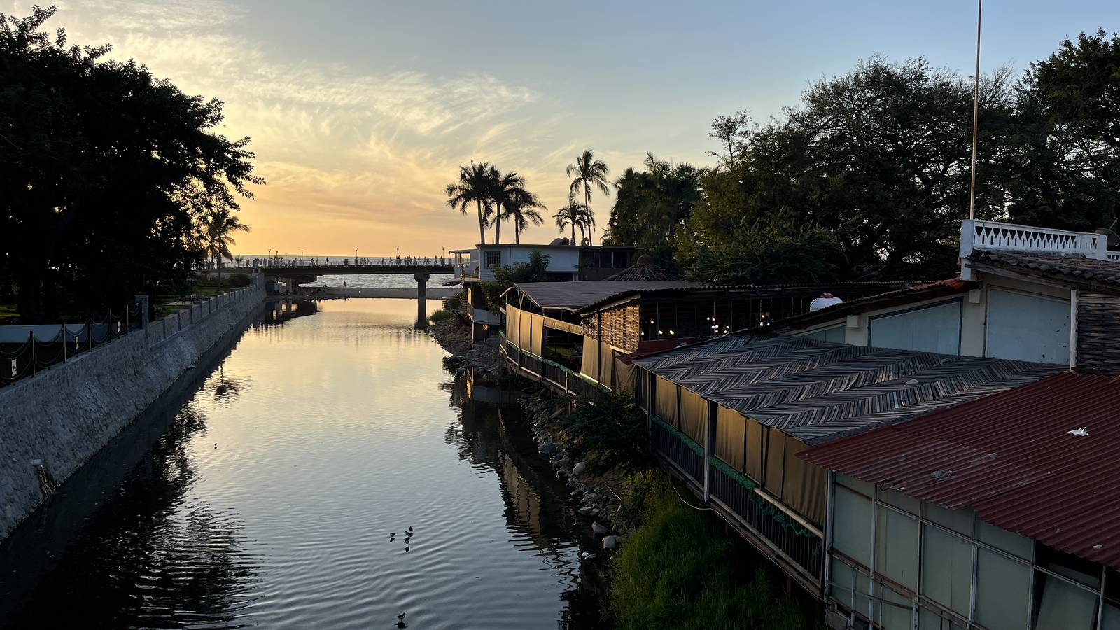 The Río Cuale at sunset, with buildings on the island and the footbridge to the Malecón